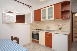 a small kitchen with a sink and a stove at Apartments by the sea Postira, Brac - 740 in Postira