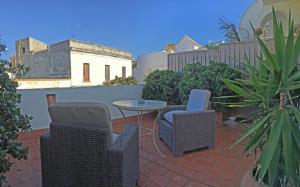 a patio with two chairs and a table on a brick patio at Benali Guest House in Tarifa