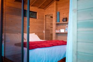 a bedroom with a bed in a wooden cabin at Caralsol Glamping in Rionegro
