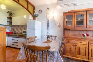 Una cocina con una mesa y un refrigerador blanco. en Apartments by the sea Sumartin, Brac - 764, en Sumartin