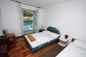 sypialnia z łóżkiem, kanapą i oknem w obiekcie Apartments by the sea Stomorska, Solta - 781 w mieście Stomorska