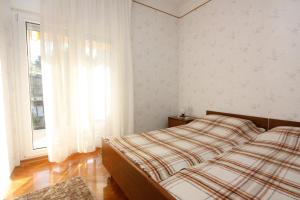 a bedroom with a bed and a large window at Apartments by the sea Stomorska, Solta - 778 in Stomorska