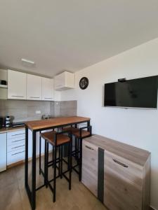 a kitchen with a table with stools and a television on the wall at Studio MM Kopaonik in Kopaonik