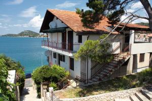 a house on the side of a hill next to the ocean at Apartments by the sea Tisno, Murter - 810 in Tisno