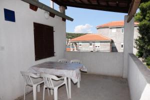 a table and chairs on the balcony of a house at Apartments by the sea Tisno, Murter - 810 in Tisno +17 photos