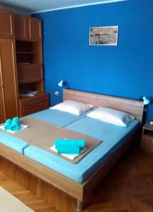 a blue bedroom with a bed with a blue wall at Apartments by the sea Tisno, Murter - 814 in Tisno