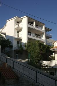 a white building with a fence in front of it at Apartments by the sea Duce, Omis - 945 in Duće