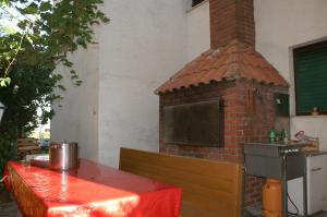 a brick oven with a table in front of a grill at Apartments by the sea Duce, Omis - 945 in Duće