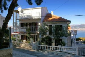 a white house with a balcony and the ocean at Apartments by the sea Slatine, Ciovo - 972 in Trogir