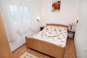 a small bedroom with a bed and a window at Apartments by the sea Slatine, Ciovo - 972 in Trogir