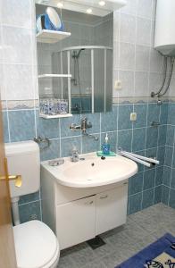 a bathroom with a sink and a toilet and a mirror at Apartments by the sea Slatine, Ciovo - 972 in Trogir