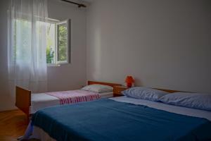 twee bedden in een kamer met een raam bij Apartments with a parking space Slatine, Ciovo - 973 in Slatine