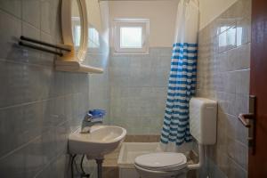 een badkamer met een wit toilet en een wastafel bij Apartments with a parking space Slatine, Ciovo - 973 in Slatine