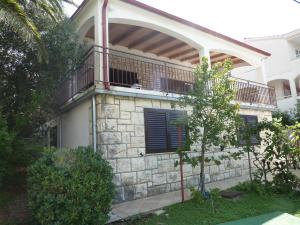 a house with a balcony on top of it at Apartments by the sea Seget Vranjica, Trogir - 976 in Seget Vranjica