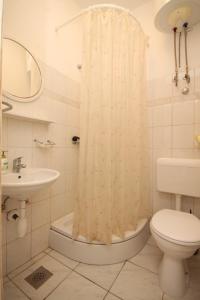 La salle de bains est pourvue d'un lavabo et d'un rideau de douche. dans l'établissement Apartment Lucica 990b, à Lastovo