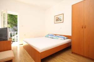 um pequeno quarto com uma cama e uma televisão em Apartments and rooms by the sea Lucica, Lastovo - 990 em Lastovo