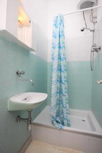 uma casa de banho com um lavatório e uma cortina de chuveiro em Apartments by the sea Biograd na Moru, Biograd - 858 em Biograd na Moru