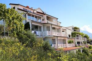 um edifício com varandas brancas numa colina em Apartments by the sea Pisak, Omis - 1014 em Pisak