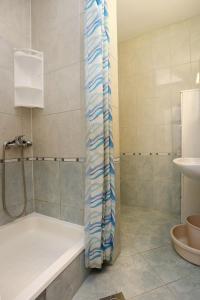 uma casa de banho com um chuveiro, uma banheira e um lavatório. em Apartments by the sea Pisak, Omis - 1014 em Pisak