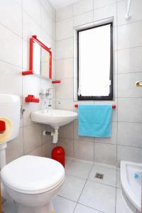 łazienka z toaletą, umywalką i oknem w obiekcie Studio Marusici 1024a w Mimicach