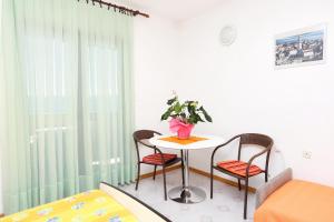 Pokój ze stołem, 2 krzesłami i łóżkiem w obiekcie Studio Marusici 1024a w Mimicach