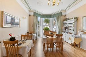 a dining room with tables and chairs and windows at Kings Lodge in Torquay