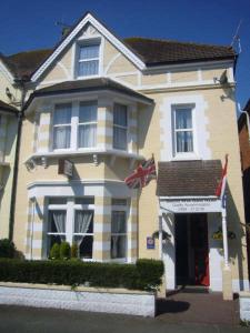 a large house with a flag in front of it at Buenos Aires Guest House in Bexhill