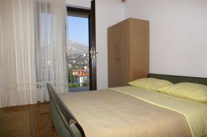 a bedroom with a bed and a large window at Apartments by the sea Seget Vranjica, Trogir - 1050 in Seget Vranjica