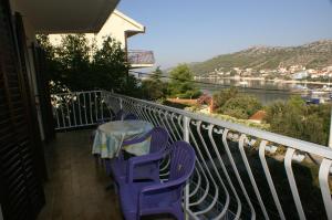 uma mesa e cadeiras numa varanda com vista em Apartments by the sea Seget Vranjica, Trogir - 1050 em Seget Vranjica