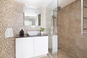 un bagno con lavandino e doccia di The Cove Noosa - Apartment 14 a Noosa Heads Altre 12 foto