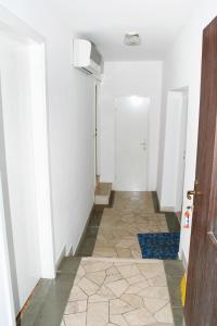 um corredor com uma porta e um piso de azulejo em Apartments by the sea Zavode, Omis - 1048 em Lokva Rogoznica