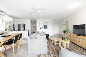 un soggiorno con divano e sala da pranzo di The Cove Noosa - Apartment 14 a Noosa Heads