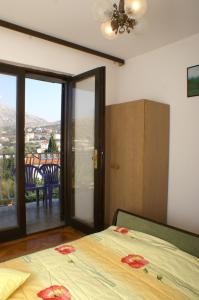 a bedroom with a bed and a sliding glass door at Apartment Seget Vranjica 1050b in Seget Vranjica