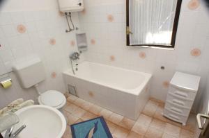 a bathroom with a tub and a toilet and a sink at Apartment Seget Vranjica 1050b in Seget Vranjica