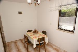 a dining room with a table with chairs and a window at Apartment Seget Vranjica 1050b in Seget Vranjica