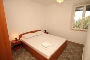 a small bedroom with a bed and a window at Double Room Lucica 990a in Lastovo