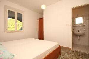 een slaapkamer met een bed, een wastafel en een raam bij Twin Room Lucica 990c in Lastovo