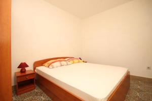 a small bedroom with a bed and a night stand at Twin Room Lucica 990b in Lastovo