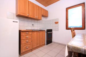 a small kitchen with wooden cabinets and a table at Apartment Zman 887c in Žman