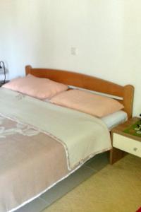 un letto con testiera in legno accanto a un tavolo di Apartments by the sea Zdrelac, Pasman - 689 a Ždrelac