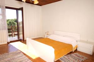 a white bedroom with a bed and a large window at Apartments by the sea Privlaka, Zadar - 666 in Privlaka