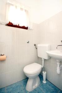 a white bathroom with a toilet and a sink at Apartments by the sea Tkon, Pasman - 822 in Tkon