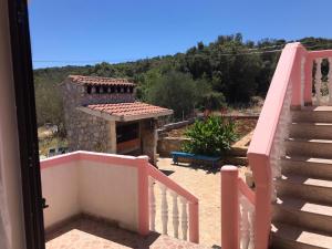 a balcony with a pink staircase and a building at Apartments with a parking space Kraj, Pasman - 819 in Tkon