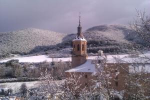 una vecchia chiesa con una montagna innevata sullo sfondo di La Morada de San Millán a San Millán de la Cogolla