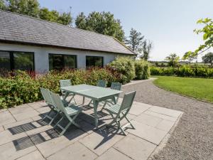 une table et des chaises vertes sur la terrasse dans l'établissement The Visiting House, à Dunmore