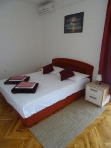 sypialnia z dużym białym łóżkiem z czerwonymi poduszkami w obiekcie Apartment Biograd na Moru 860b w Biogradzie na Moru