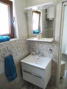 W łazience znajduje się umywalka, lustro i wanna. w obiekcie Apartment Biograd na Moru 860b w Biogradzie na Moru