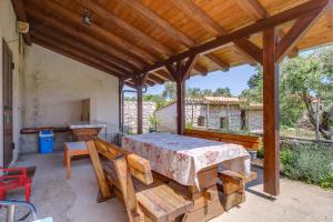 a covered patio with a table and benches at Apartments with a parking space Punta kriza, Cres - 867 in Punta Križa