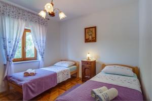 a bedroom with two beds and a window at Apartments with a parking space Punta kriza, Cres - 867 in Punta Križa
