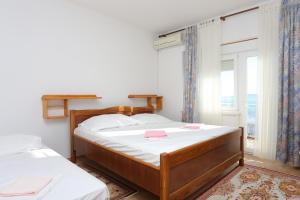 a bedroom with two beds and a window at Apartments with parking space Marusici, Omis - 954 in Mimice